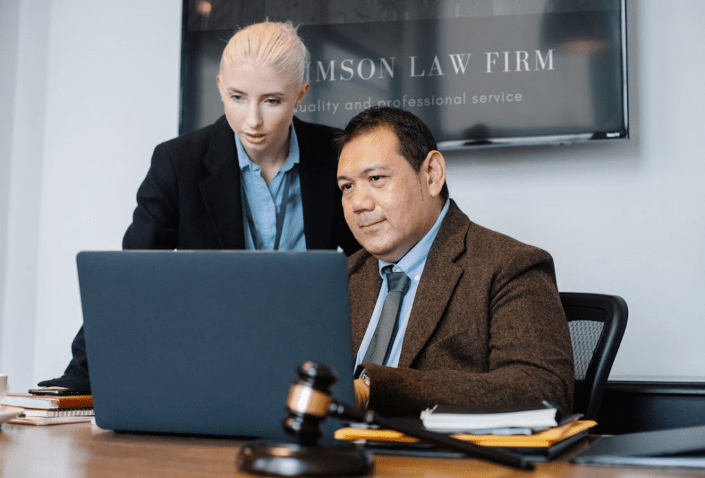 Two attorneys reviewing case files in a modern law firm conference room